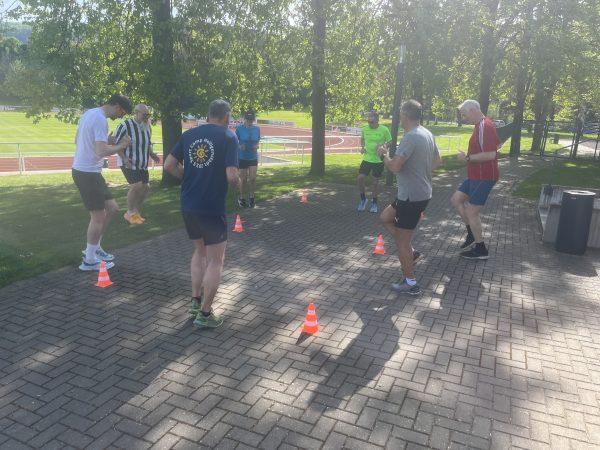 Eine Gruppe von Läufern die ein professionelles Lauf-ABC durchführt
