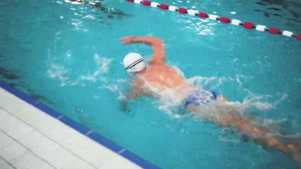 Athletischer Schwimmer im Schwimmbad beim Personal Training